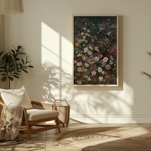 May include: A framed print of a floral arrangement featuring a variety of pink, white, and purple flowers on a dark background. The print is hanging on a white wall in a living room setting.