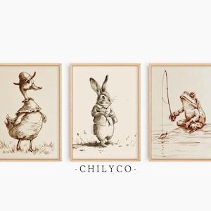 Könnte beinhalten: Set aus drei gerahmten Vintage-Prints mit Tierillustrationen. Die Bilder zeigen eine Ente mit Hut, ein Kaninchen in einer Jacke und einen Frosch beim Angeln. Die Kunstwerke sind in Sepia-Tönen gehalten, mit hellem Beige-Hintergrund und Holzrahmen.