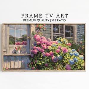 Könnte beinhalten: Ein Gemälde, das ein Haus mit einem Fenster und einem Blumengarten zeigt. Das Haus ist in Blautönen und Grau gestrichen, und das Fenster ist offen. Der Garten ist mit rosa, blauen und violetten Blumen gefüllt. Das Gemälde ist in einem hellen Holzrahmen gerahmt.