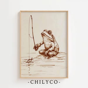 May include: A sepia-toned framed print featuring a frog fishing. The frog, with a contemplative expression, sits on a rock, holding a fishing rod. A small fish is visible in the water. The text "-CHILYCO-" is at the bottom.