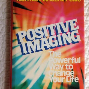 Może przedstawiać: Okładka książki z tytułem "POSITIVE IMAGING" dużymi niebieskimi i białymi literami. Nazwisko autora, Norman Vincent Peale, jest żółte u góry. Tło to kolorowa mieszanka czerwieni, pomarańczy, błękitu i zieleni.