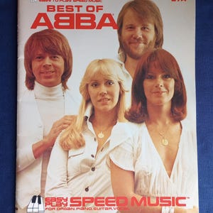 Könnte beinhalten: Ein Vintage-Notenbuchcover mit der Band ABBA. Das Cover zeigt den Text "BEST OF ABBA" in Rot, mit den Gesichtern der Bandmitglieder. Der Text "EASY TO PLAY SPEED MUSIC" befindet sich oben und unten.