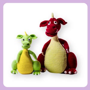 Puede incluir: Dos juguetes de dragón de crochet. Uno es rojo con la barriga amarilla y el otro es verde con la barriga amarilla.