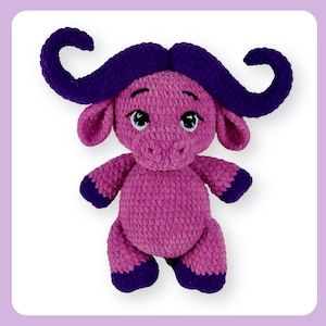 May include: A handmade buffalo plush toy. The toy is a soft pink colour with dark purple accents on the horns, hooves, and ears. It has blue eyes and a friendly expression, suitable for a child's room or as a decorative item.