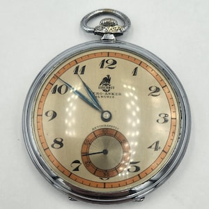 May include: A vintage pocket watch with a silver-tone case and a cream-colored face. The watch face features black numerals, a small seconds dial, and the text "BISCHOFF, CRO-ANKER, 15 RUBIS, ANTIMAGNETIC". The hands are blue.
