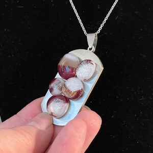 Red and brown fused glass with sparkling dichroic on silver pendant