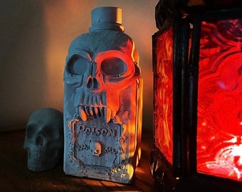 Concrete vampire skull poison bottle and skull set.