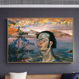May include: A framed oil painting depicting a self-portrait of a man with dark hair and blue eyes, set against a coastal landscape with a sunset. The artwork is displayed above a brown leather sofa.