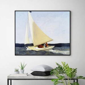 Op de afbeelding: Een ingelijst schilderij van een zeilboot op het water. De boot is geel met een crèmekleurig zeil. Het water is donkerblauw en de lucht lichtblauw. Het schilderij wordt aan een witte muur getoond.