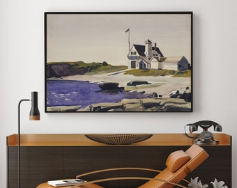 May include: Framed artwork depicting a coastal scene with a white building, a flagpole with a flag, and a shoreline with rocks and water. The painting has a black frame and is displayed above a dark brown cabinet.
