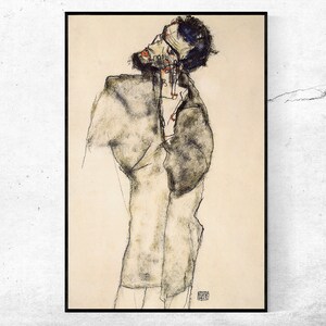 May include: A framed print of an abstract drawing. The artwork depicts a figure with a tilted head, rendered in charcoal and colored pencil. The figure is wearing a coat. The color palette is primarily black, white, and beige.