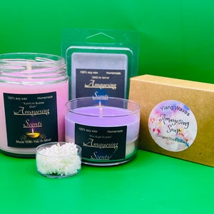 May include: Three glass jars of soy wax candles with labels that say "Amayesing Scents". The candles are in the scents "Yummy Yum Bubble Gum", "Sugar Crumble", and "Ylang Waves". There is also a brown box with a label that says "Amayesing Soap" with the scent "Ylang Waves".
