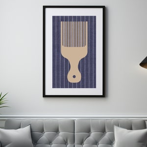 May include: A framed print of a beige comb on a blue and white striped background.