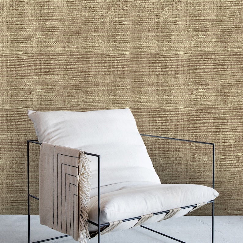 May include: A white chair with a black metal frame sits in front of a wall with a brown woven texture. The chair has a white cushion and a black and white throw draped over the back.