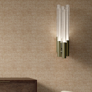 May include: A modern wall sconce with a brushed gold finish and clear glass tubes. The sconce is mounted on a beige textured wall.