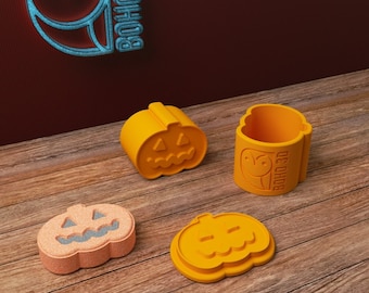 May include: Four orange pumpkin-shaped Halloween treat boxes with a carved jack-o'-lantern face. The boxes are made of 3D printed plastic and have the logo "BOHO 3D" printed on the side.