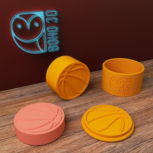Könnte beinhalten: Vier orangefarbene und rosafarbene 3D-gedruckte Basketball-Formen mit dem Text "BOHO 3D" auf einer der Formen.