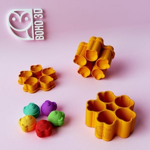 May include: A collection of orange plastic multi-cavity molds and small colorful bear-shaped figures in green, purple, yellow, and red. The text BOHO 3D is visible in the upper left corner and embossed on the side of the largest orange mold.