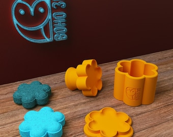 May include: Four flower-shaped molds, two are teal and two are orange. The orange molds are taller than the teal molds. The orange molds have the text "BOHO 3D" on the side.