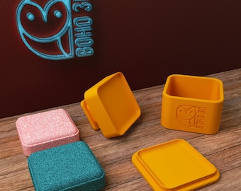 May include: Four small square boxes with lids. Two are yellow, one is pink, and one is teal. The boxes have a small owl logo with the text "BOHO 3D" on them.