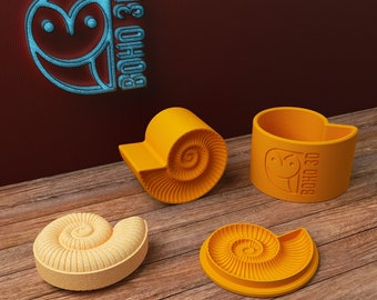 May include: Four yellow ceramic ammonite shaped planters with the text "BOHO 3D" on one of the planters.