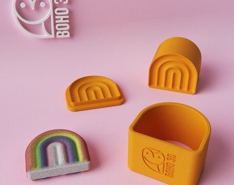 May include: A set of four orange rainbow-shaped cookie cutters. The cutters are made of plastic and have a smooth finish. The set includes a large rainbow, a small rainbow, a half rainbow, and a rainbow ring. The cutters are perfect for making rainbow-shaped cookies, cakes, and other treats.