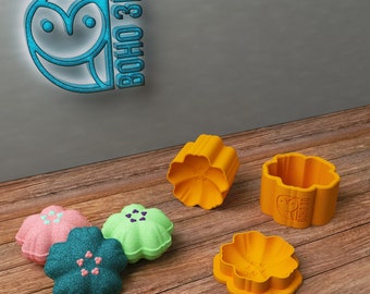 May include: Five orange flower-shaped silicone molds, two are closed and three are open. The molds are on a wooden surface. The closed molds have the text "BOHO 3D" on the side.
