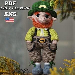 May include: A handmade crochet leprechaun doll wearing a green hat with a shamrock, a green shirt, brown overalls, and blue shoes. The doll has a red beard and is holding a small green shamrock. The text "PDF CROCHET PATTERN ENG" is in the upper left corner.