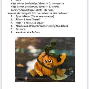 May include: A crocheted pumpkin toy with a sad face, orange body, green stem, and brown eyes. The pumpkin is sitting on a wooden surface. The toy is 13 cm tall.