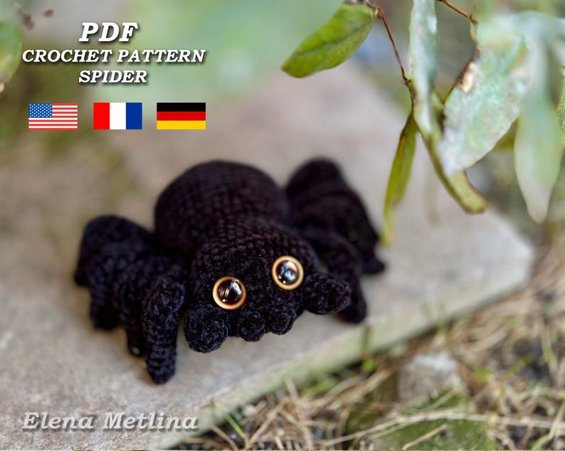 Peut inclure: Un mod&egrave;le de crochet d'araign&eacute;e noire avec de grands yeux brun dor&eacute;. Le texte "PDF CROCHET PATTERN SPIDER" et le nom "Elena Metlina" sont visibles. Les drapeaux des &Eacute;tats-Unis, de la France et de l'Allemagne sont &eacute;galement pr&eacute;sents.