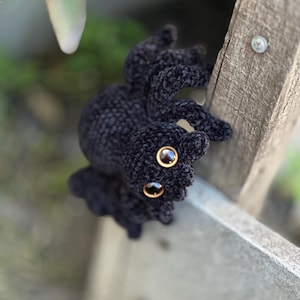 Peut inclure: Un crochet noir en forme d'araign&eacute;e avec de grands yeux ambr&eacute;s. L'araign&eacute;e en peluche a un aspect textur&eacute; et velout&eacute;. Les pattes de l'araign&eacute;e sont l&eacute;g&egrave;rement incurv&eacute;es, lui donnant une apparence r&eacute;aliste. Objet artisanal unique.