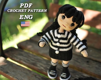 Könnte beinhalten: Häkelmuster-PDF in Englisch für eine schwarz-weiß gestreifte Puppe mit schwarzen Haaren und weißen Knöpfen. Die Puppe trägt einen schwarzen Rock und schwarz-weiß gestreifte Socken.
