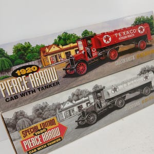 May include: Two model boxes of 1920 Pierce Arrow cab with tanker trucks. One box features a red truck with "Texaco Petroleum Products" and a star logo. The other box shows a black and white truck with the Texaco logo. Both boxes have the text "Collector Series".