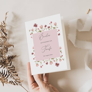 Könnte beinhalten: Eine rosa und weiße Karte mit einem floralen Rand. Die Karte sagt "Emilia" und "Gottesdienst zur Taufe" mit dem Datum "06. August 20xx".