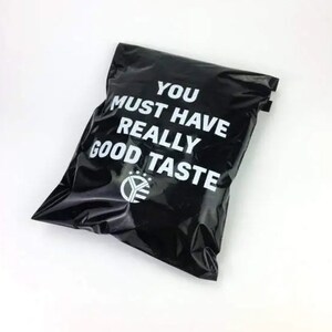 Könnte beinhalten: Schwarzer Poly-Versandbeutel mit weißem Text "You must have really good taste" und einem Logo mit einem Stern und den Buchstaben "YE".