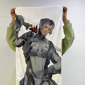 May include: White rectangular body pillow with a detailed illustration of a male character in futuristic armour, holding a sword. The character has grey hair and a determined expression. The pillow is held up against a white wall.