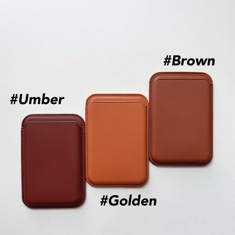 May include: Three leather phone cases in different colors: brown, orange, and red. The cases are labeled with the hashtags #Brown, #Golden, and #Umber.