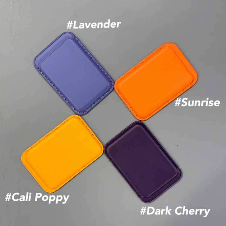 May include: Four different colored leather phone wallets, each with a stitched edge. The colors are lavender, sunrise orange, cali poppy orange, and dark cherry purple. Each wallet has a hashtag with the color name.
