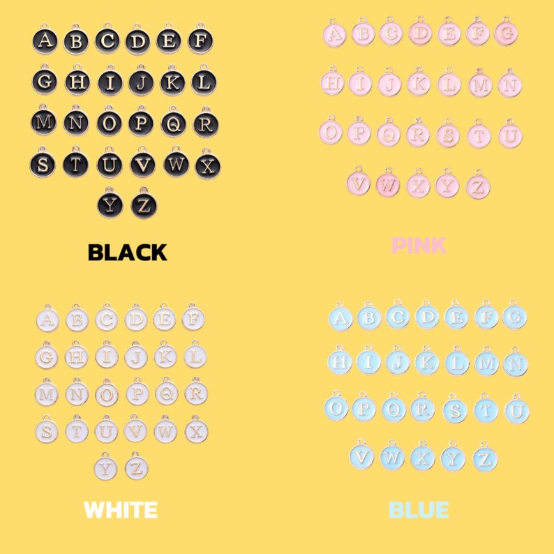 May include: A set of alphabet letter charms in four colours: black, white, pink, and blue. Each letter is a separate charm with a gold rim.