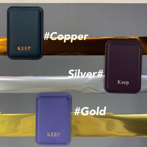 May include: Three phone wallet cases in different colors: navy blue, purple, and burgundy. Each case has the word "KEEP" embossed in gold lettering. The cases are displayed on a gray background with gold, silver, and copper foil behind each case. The text "#Copper", "#Gold", and "#Silver" is written in white on the foil.