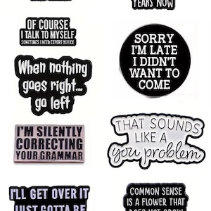 May include: A selection of black and white enamel pins with witty sayings. The pins display phrases such as "Apparently I have an attitude," "Sorry I'm late," and "That sounds like a you problem."