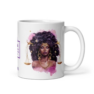 May include: White ceramic mug with a colorful illustration of a woman with dark hair and a gold crown, holding scales. The background is a watercolor wash of pink and purple.