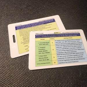 May include: Two white cards with black text. One card details the TUG score, a mobility and balance test. The other card is a BIMS score sheet, a tool for assessing cognitive function. Both cards have text and are on a dark surface.