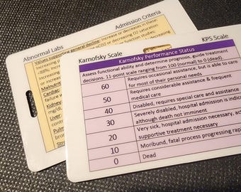 May include: Two white laminated cards with medical information. One card lists "Abnormal Labs" and "Admission Criteria." The other card displays the "Karnofsky Scale" and "Karnofsky Performance Status" with a 11-point scale ranging from 100 to 0.