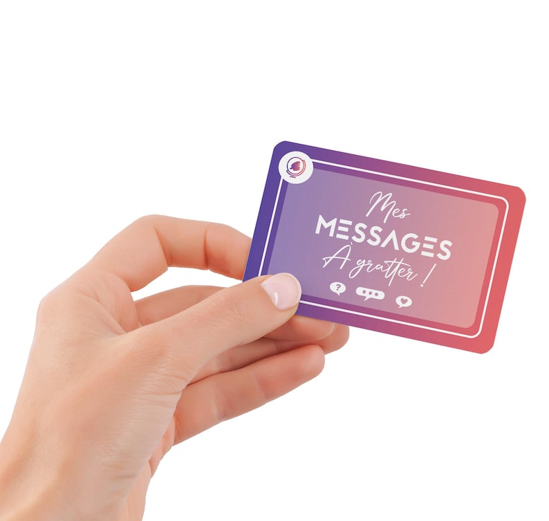 May include: A rectangular card with a gradient purple to pink background is held in a hand. The card has white text that reads "Mes MESSAGES A gratter!" with icons below. The card has a white border and a circular logo in the upper left corner.