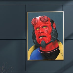 May include: A painting of a red-skinned character with horns, a black beard, and a yellow and blue shirt. The character is looking directly at the viewer with a serious expression.