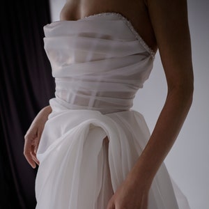 Abito da sposa con strascico lungo. Abito da sposa con corsetto. Abito da sposa con ricamo a mano. Abito con spacco.