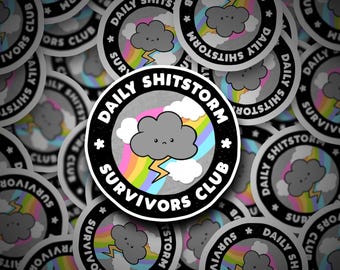 May include: A collection of round stickers with a cartoon cloud, rainbow, and lightning bolt design. The stickers have the text "DAILY SHITSTORM SURVIVORS CLUB" in a circular pattern around the cloud image. The cloud has a sad face.