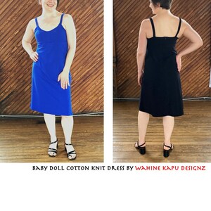 May include: Two women wearing sleeveless, knee-length, knit dresses. The dress on the left is royal blue and the dress on the right is black. Both dresses have a scoop neck and are made of a soft, stretchy fabric. The dresses are photographed against a wood panel background. "BABY DOLL COTTON KNIT DRESS BY WAHINE KAPU DESIGNZ" is printed at the bottom of the image.