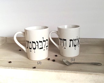 May include: Two white ceramic mugs with black Hebrew lettering. The mug on the left says "Good morning" and the mug on the right says "Coffee time".